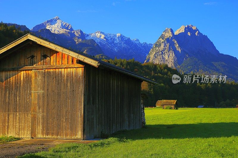 阿尔卑斯乡村木谷仓农场，与Zugspitze, Waxenstein和Alpspitze景观-戏剧性的景观在巴伐利亚阿尔卑斯山，德国，附近的卡文德尔山脉-雄伟的高山景观秋天-加尔米施，德国巴伐利亚